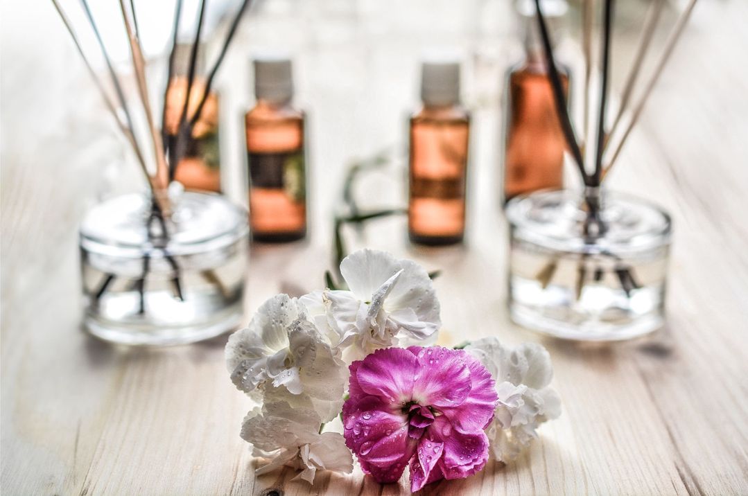 aromaolje med duftpinner og lilla blomster